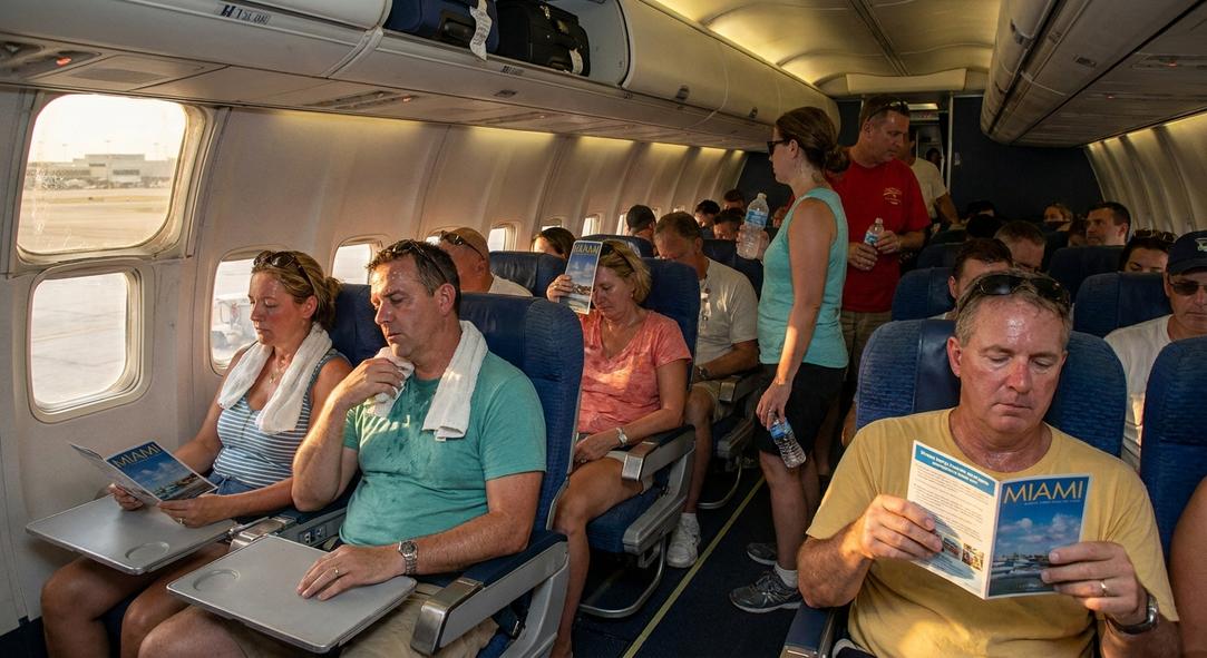 Airplane passengers reading Miami brochures during flight