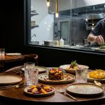 Chef plating gourmet dishes in modern restaurant kitchen